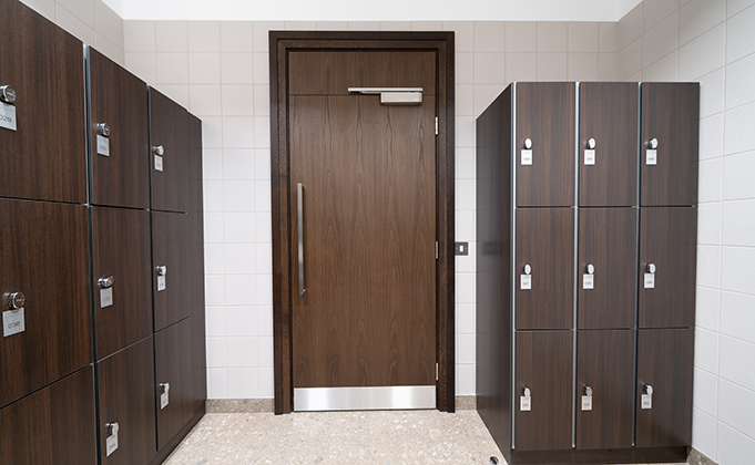 Walnut finish timber door with overhead panel and stainless steel ironmongery_commercial building_leisure_sports_locker room